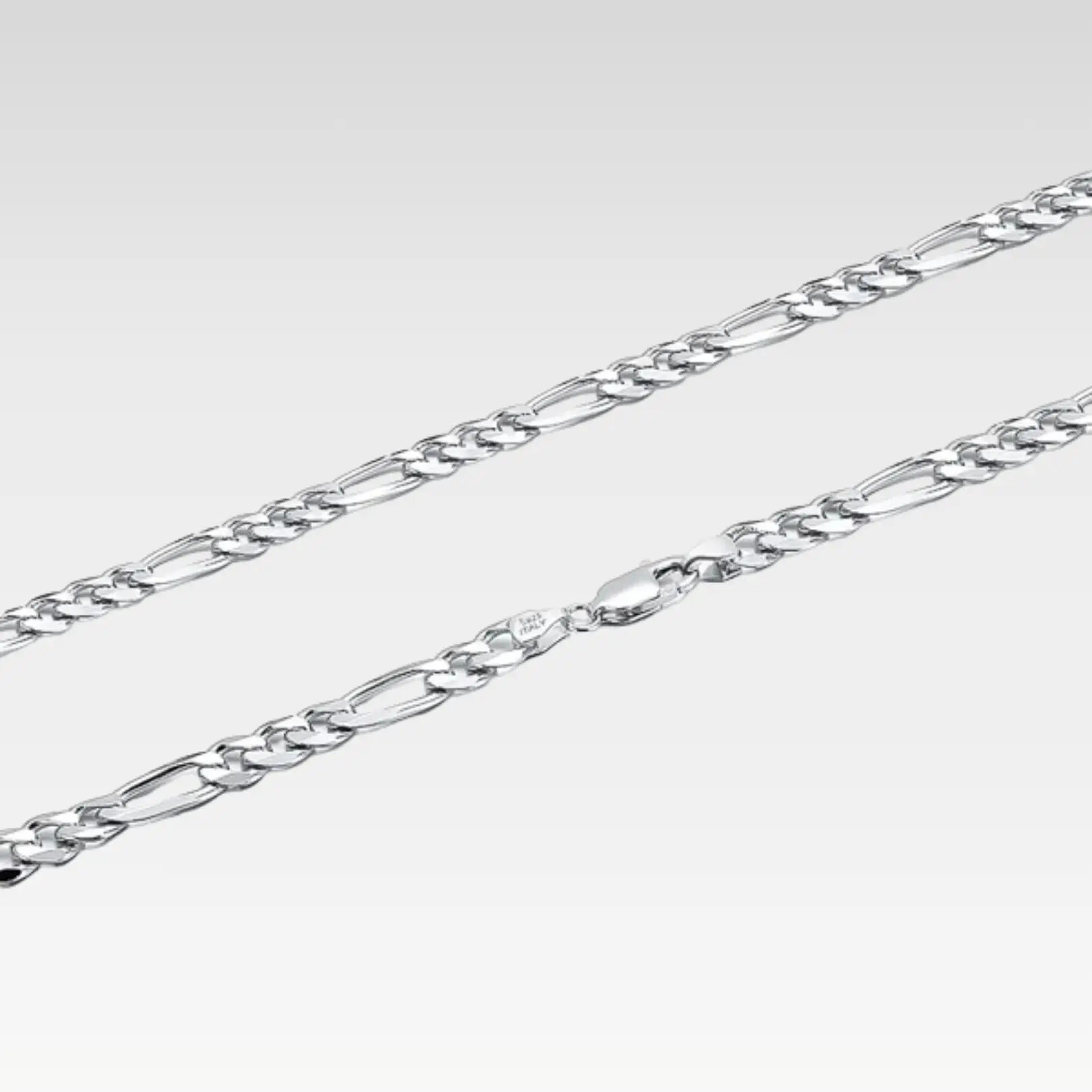 Detailed close-up of the classic sterling silver Figaro chain links, highlighting the bright, polished finish