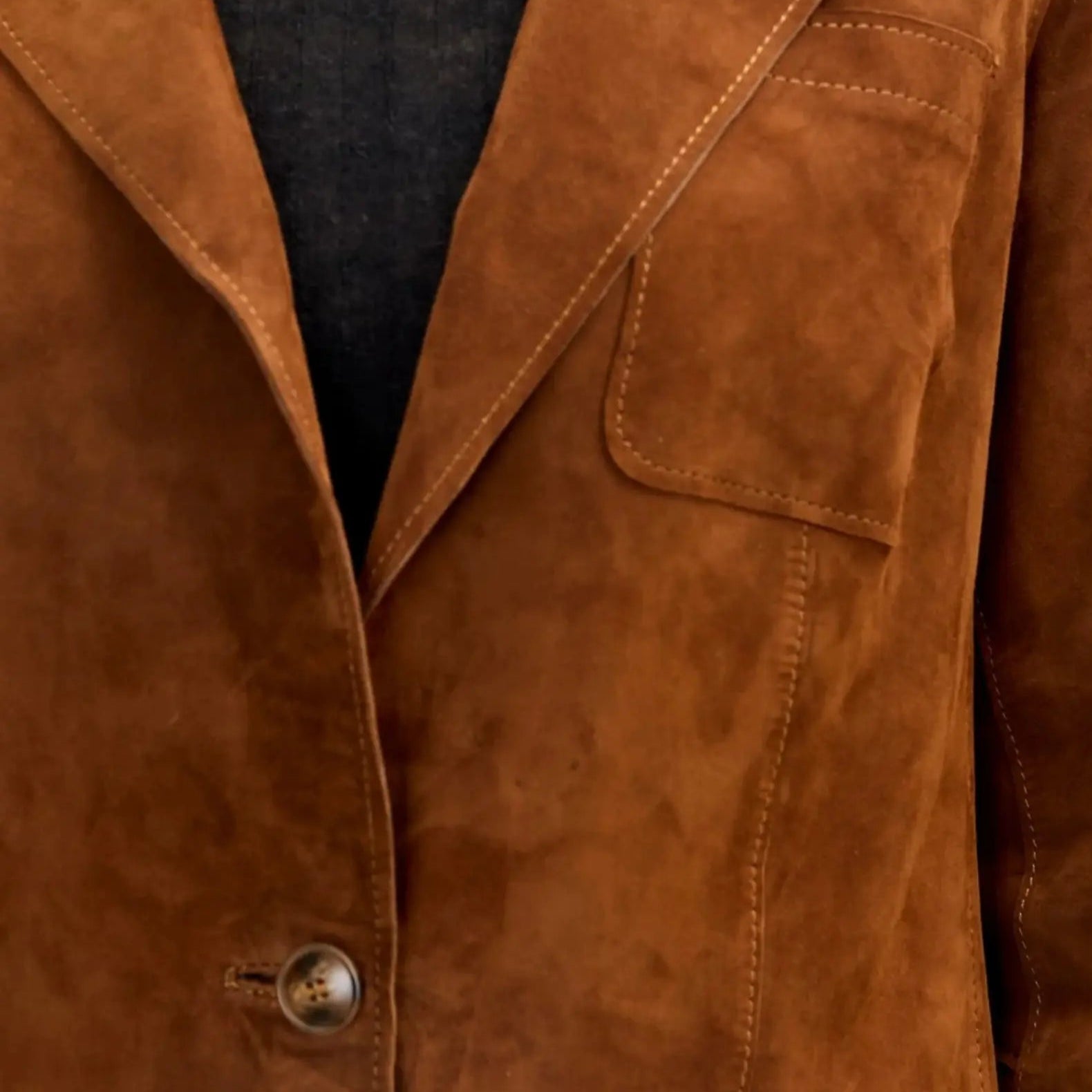 Side view of brown suede lambskin blazer highlighting relaxed fit, soft suede material, and lapel details.