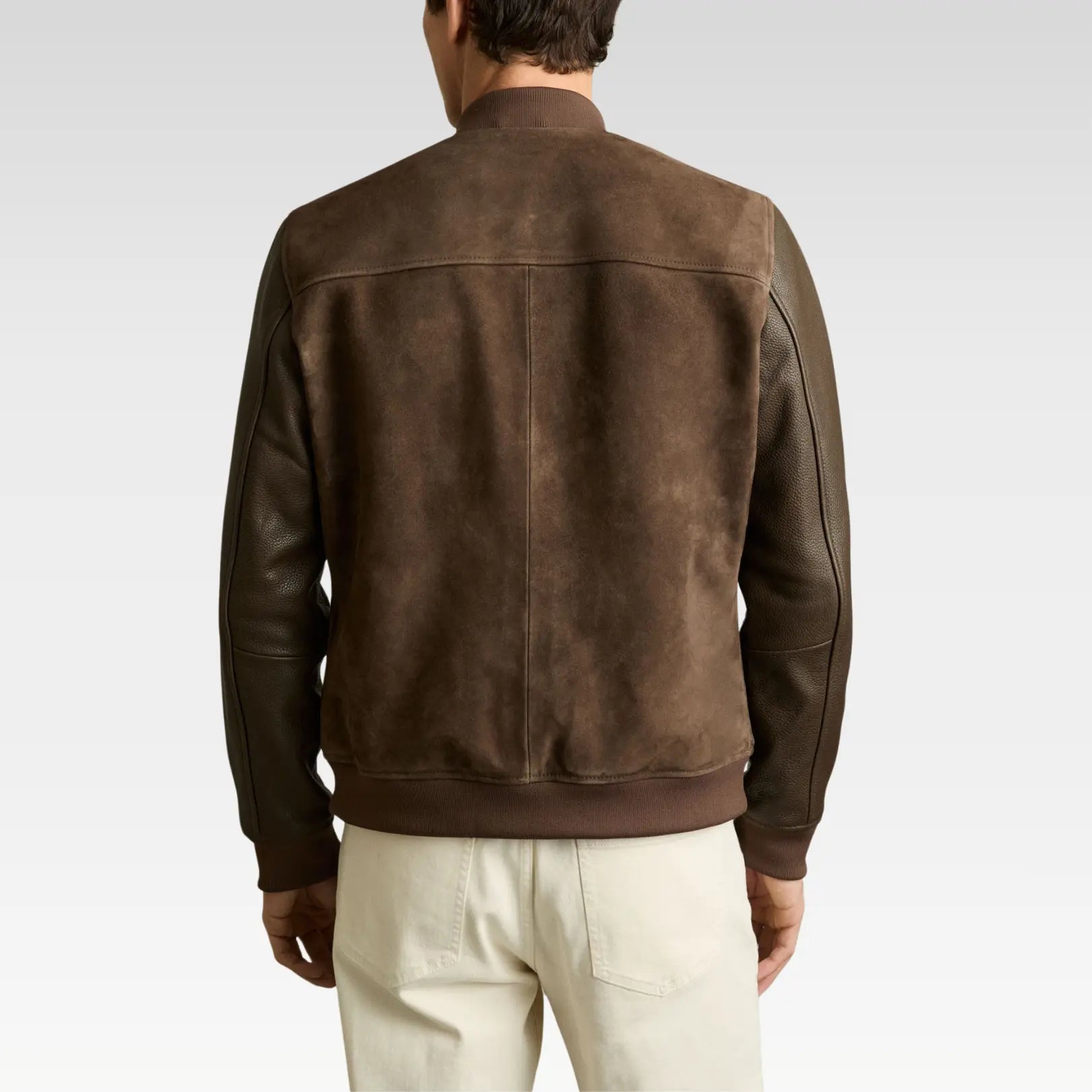 Brown leather jacket worn by a person on a plain background