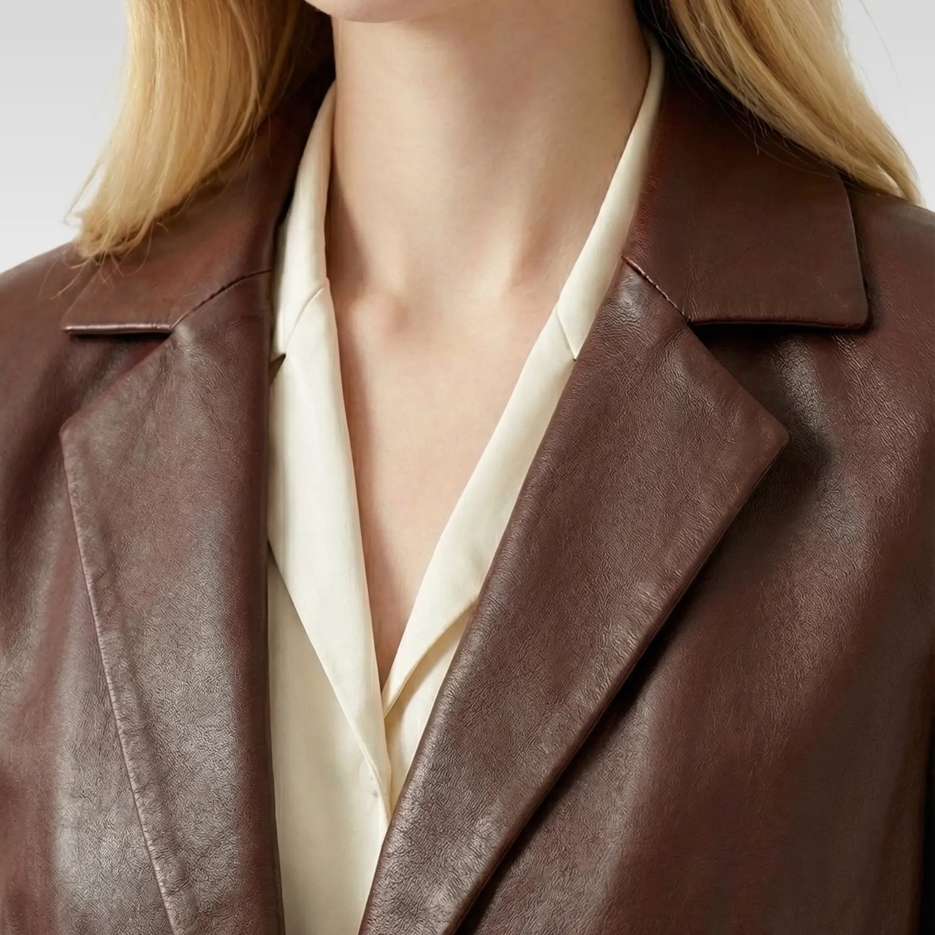 Notch lapel collar detail of women’s brown sheepskin leather blazer