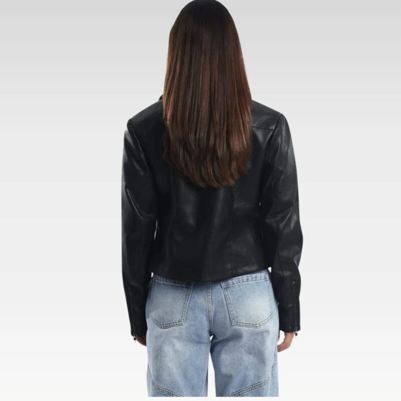 Side view of a stylish black leather jacket worn by a woman, featuring a sleek zip-up design and collared neckline, paired with light blue jeans, perfect for autumn and winter fashion.