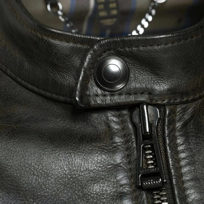 Close-up view of the zipper and stitching detail on a men's black leather jacket, highlighting premium craftsmanship and durable design.