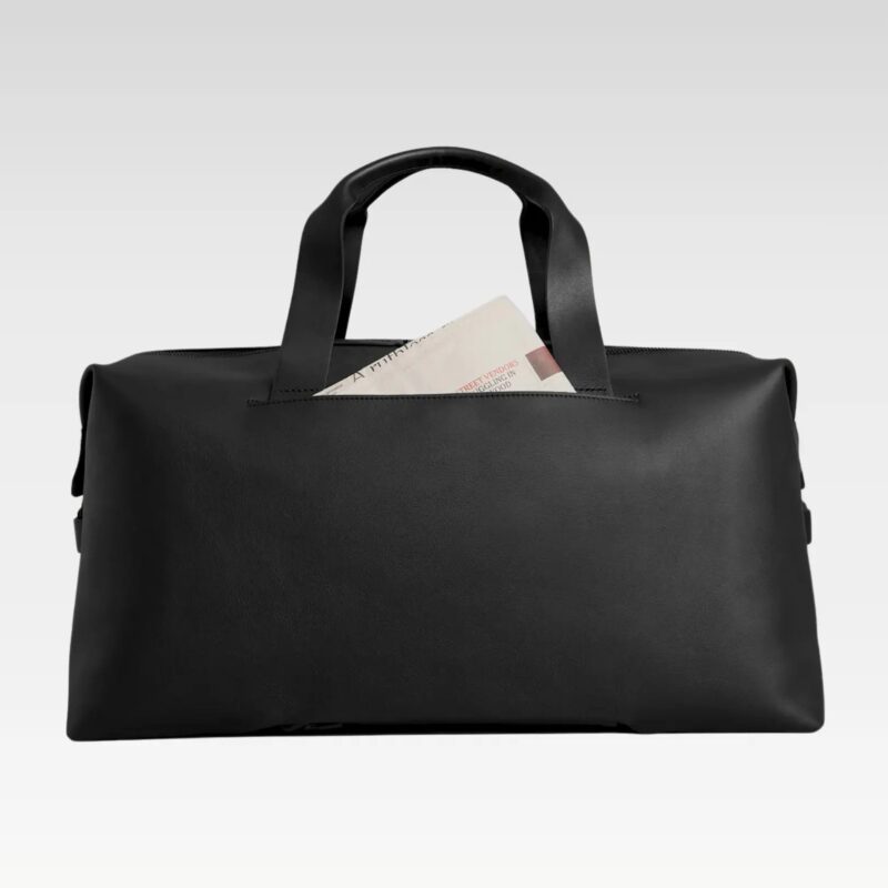 Front view of modern black leather duffle bag highlighting minimalist design, top handles, and premium waterproof materials.