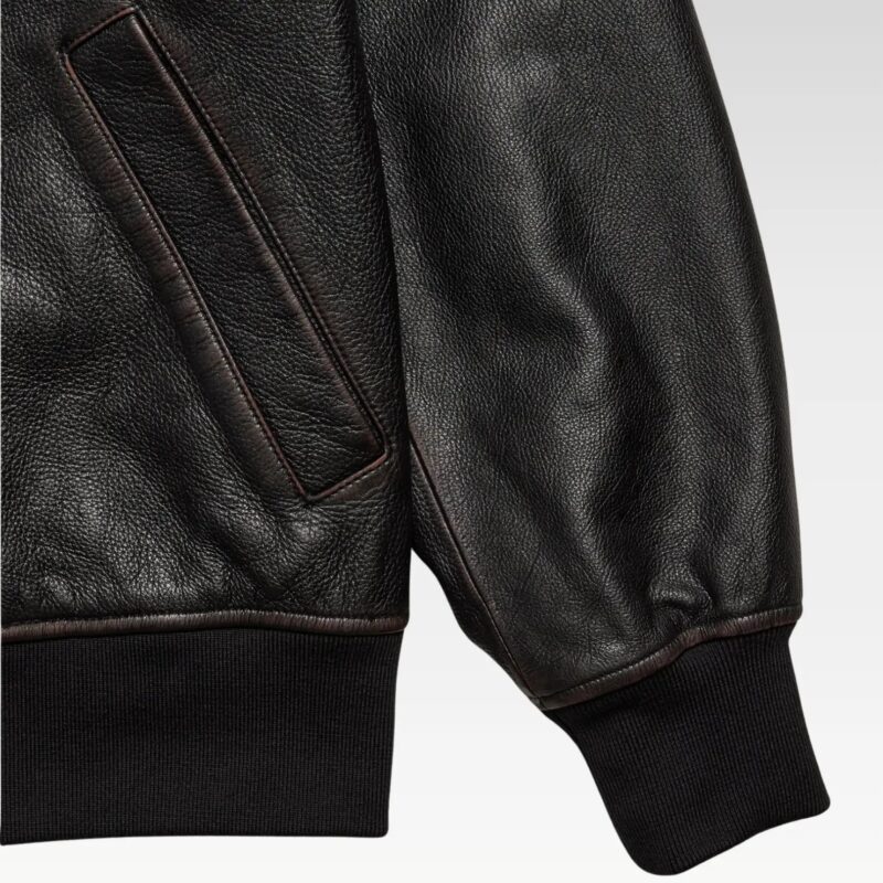 Oversized leather bomber jacket laid flat, highlighting front design, collar, and ribbed hem.