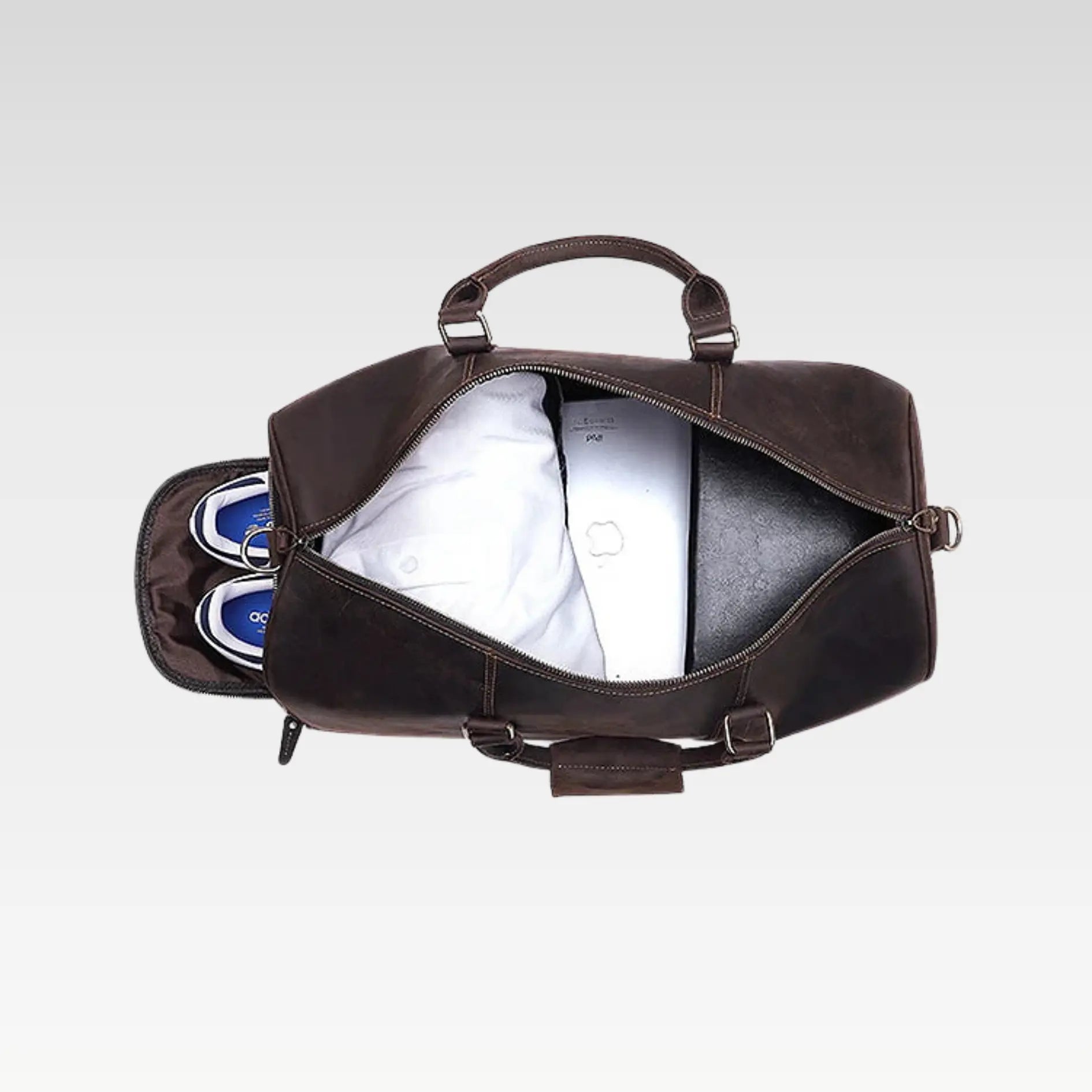 Open leather duffle bag displaying spacious interior with organized compartments and accessories inside.