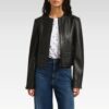 Woman styling Rebecca black collarless biker jacket with jeans in relaxed pose, highlighting the jacket's contemporary silhouette and everyday wearability