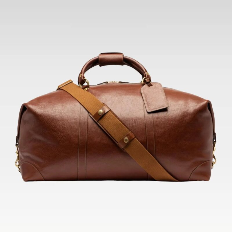 Rogue full-grain leather travel duffel bag displayed with its detachable, adjustable shoulder strap attached.