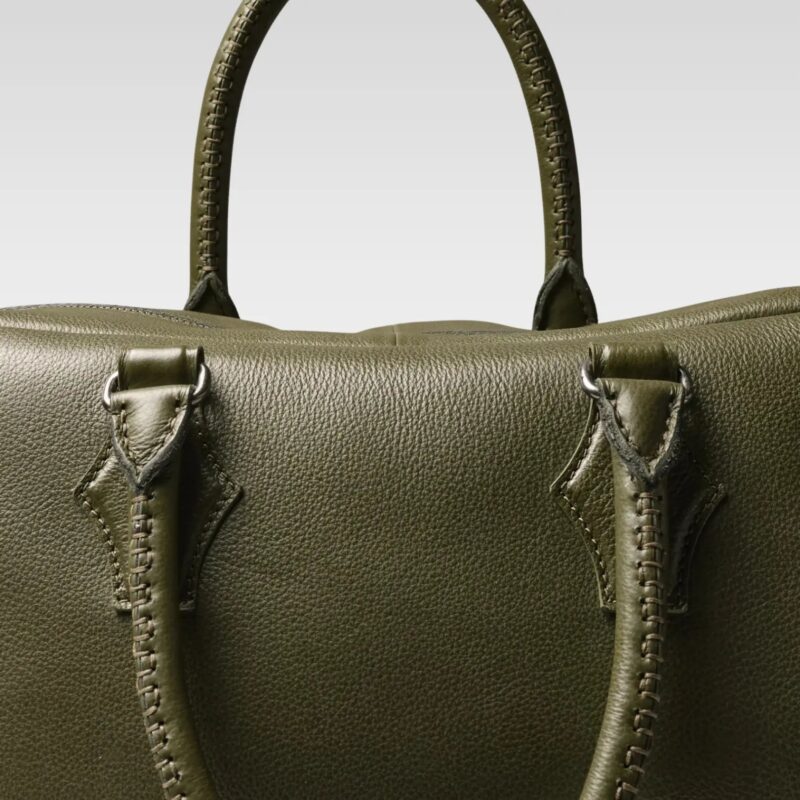 Front view of the Sable duffle bag in green, highlighting its symmetrical trapezoid shape and elegant, minimalist design.