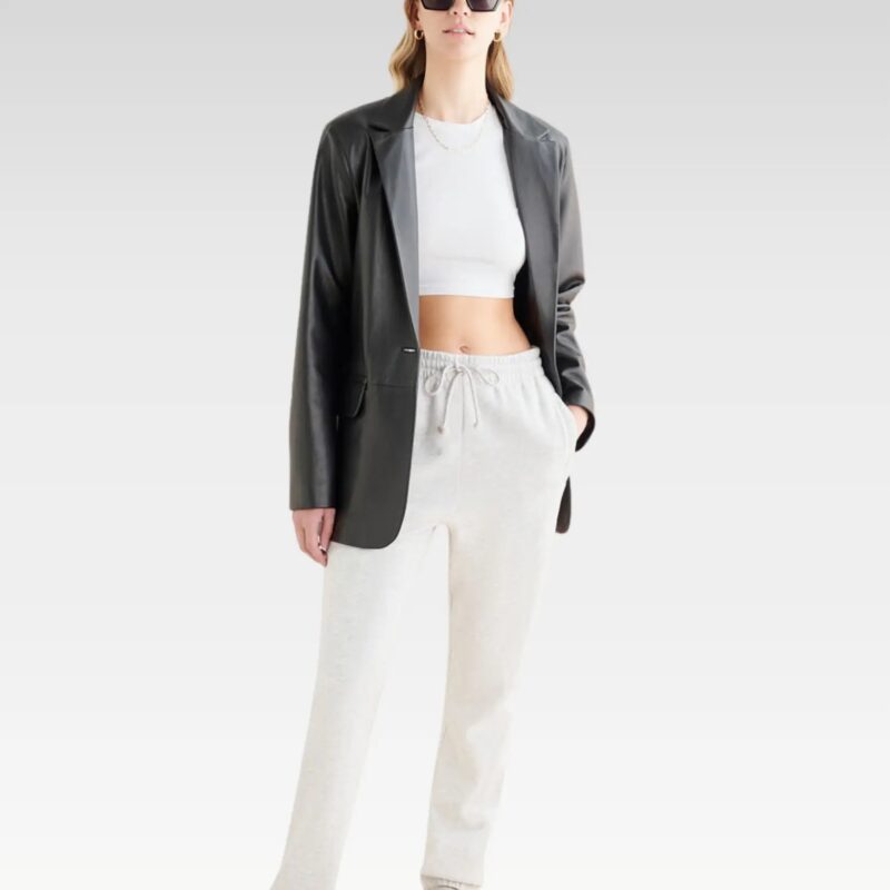 Full front view of model wearing Stand Studio Mina blazer in genuine leather paired with white outfit, illustrating relaxed fit and versatile styling.