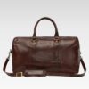 Man carrying Stratos brown full-grain leather duffle cabin bag with sturdy handles, ideal for carry-on travel