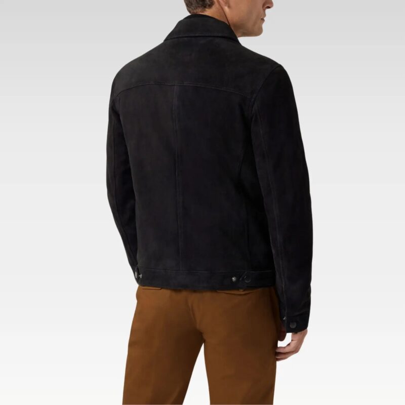 Back view of a black suede zip-through trucker jacket with adjustable side tabs, paired with brown trousers.