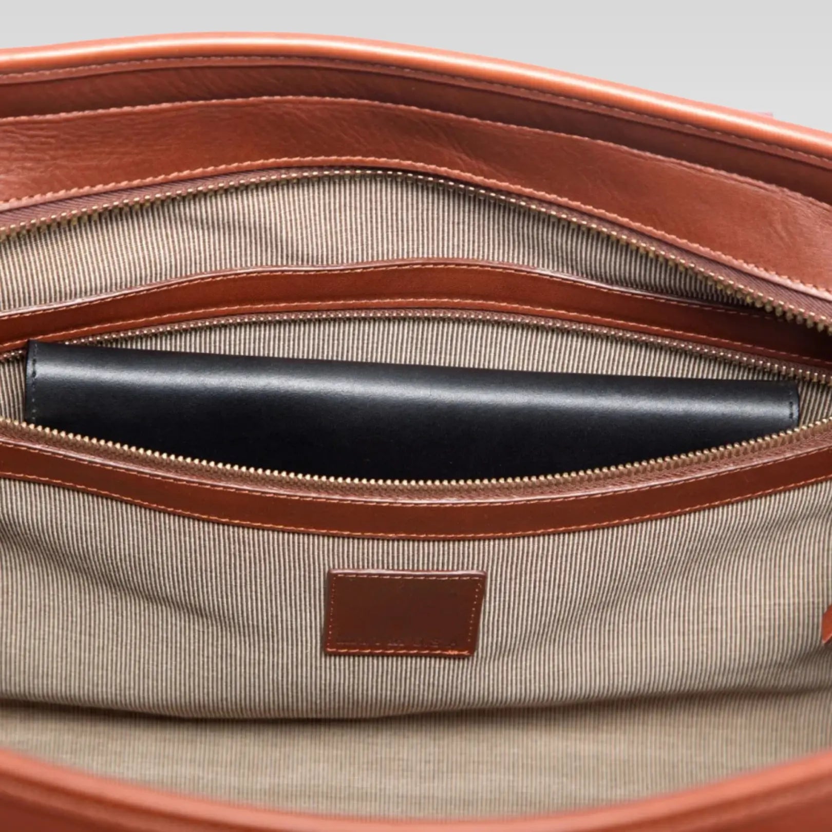 Top view of the Valor Signature Travel Duffle showing the roomy interior and optional Sunbrella lining, crafted from rich brown leather with solid brass hardware.