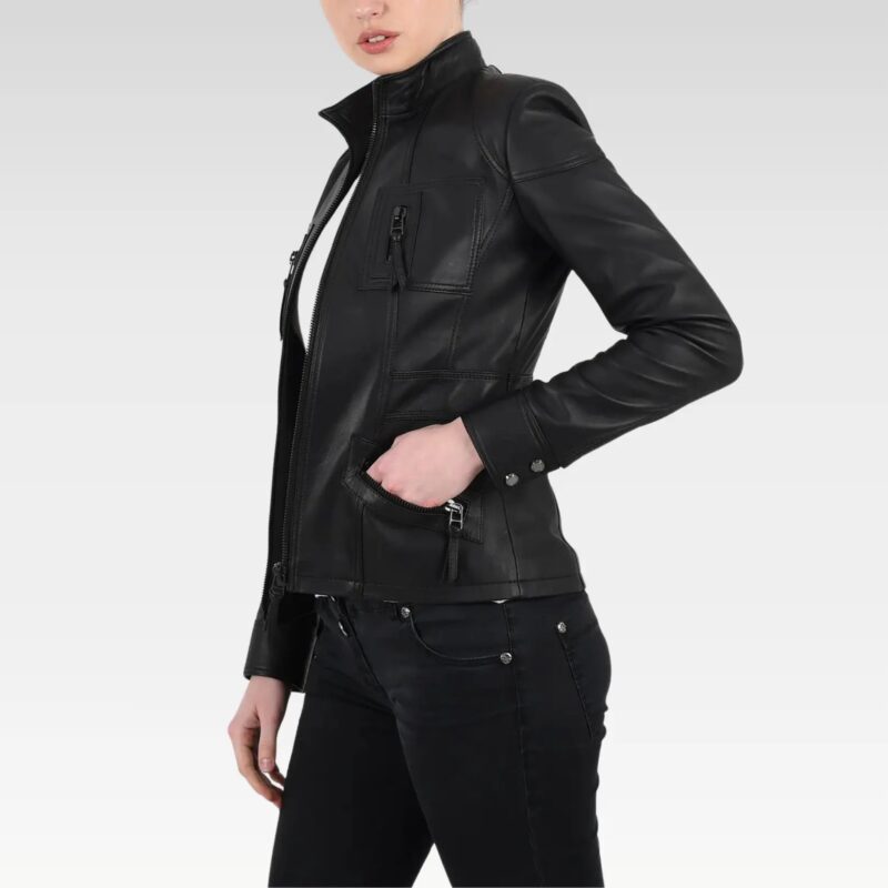 Close-up side view of a woman adjusting the front zipper of a black leather bomber jacket, emphasizing its modern fit and style.